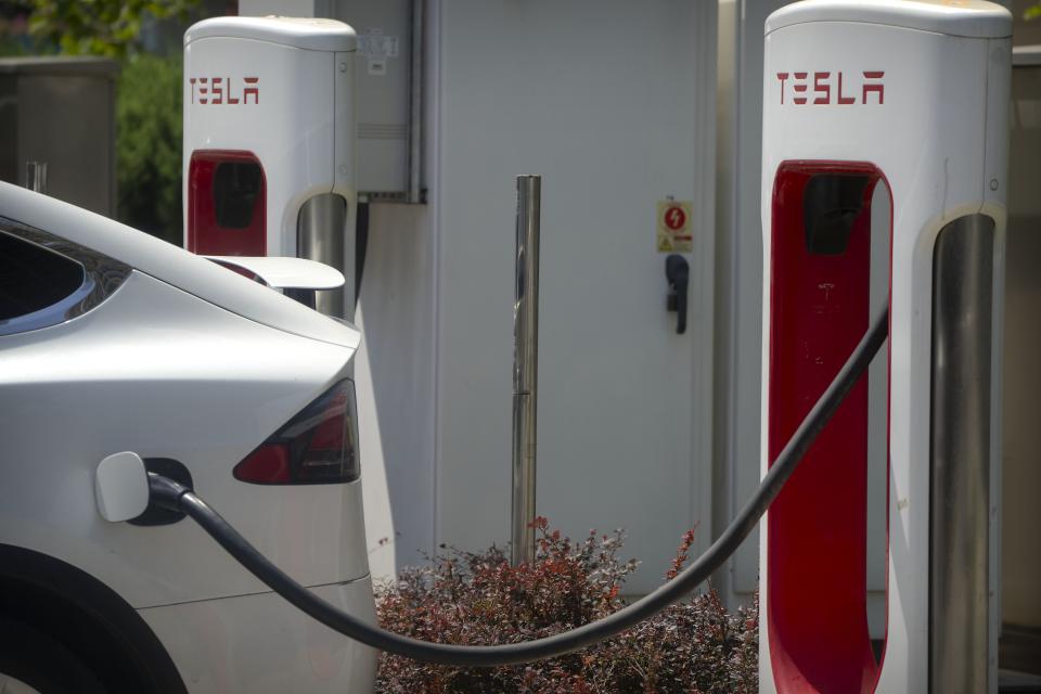 Un vehículo se carga en una estación de vehículos eléctricos fuera de un concesionario Tesla (AP /Mark Schiefelbein. Archivo)