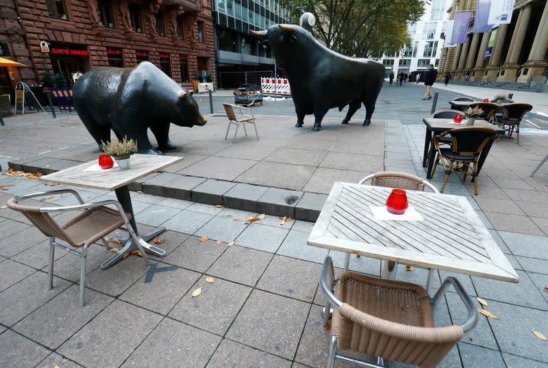 Empty tables are pictured in front of the bull and bear statues outside Frankfurt's stock exchange as the coronavirus disease (COVID-19) outbreak continues in Frankfurt