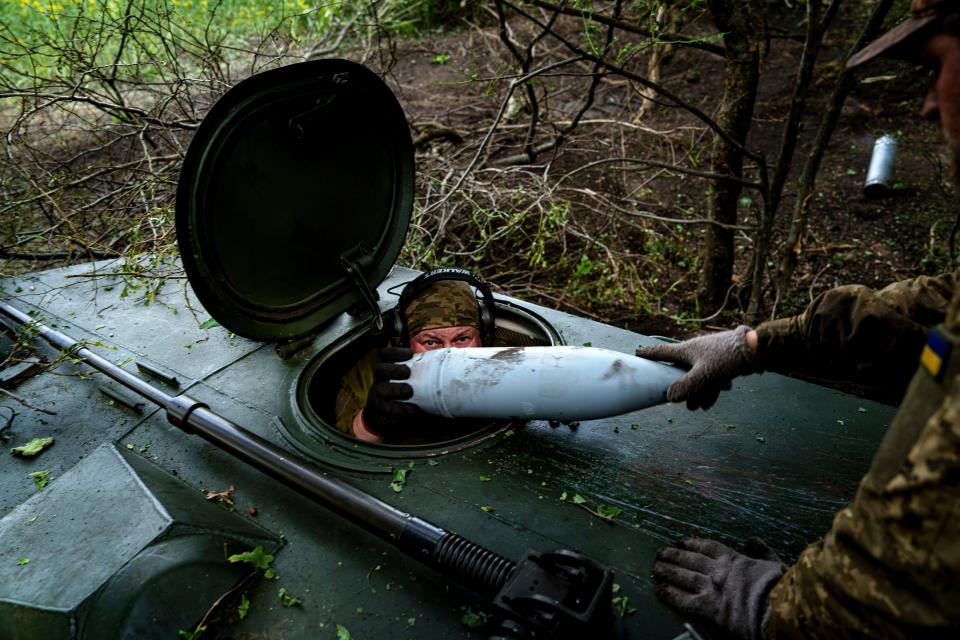 A Ukrainian soldier from the 57th Brigade loads an artillery shell to fire on Russian positions at the front line in the Kharkiv region of Ukraine (AP)