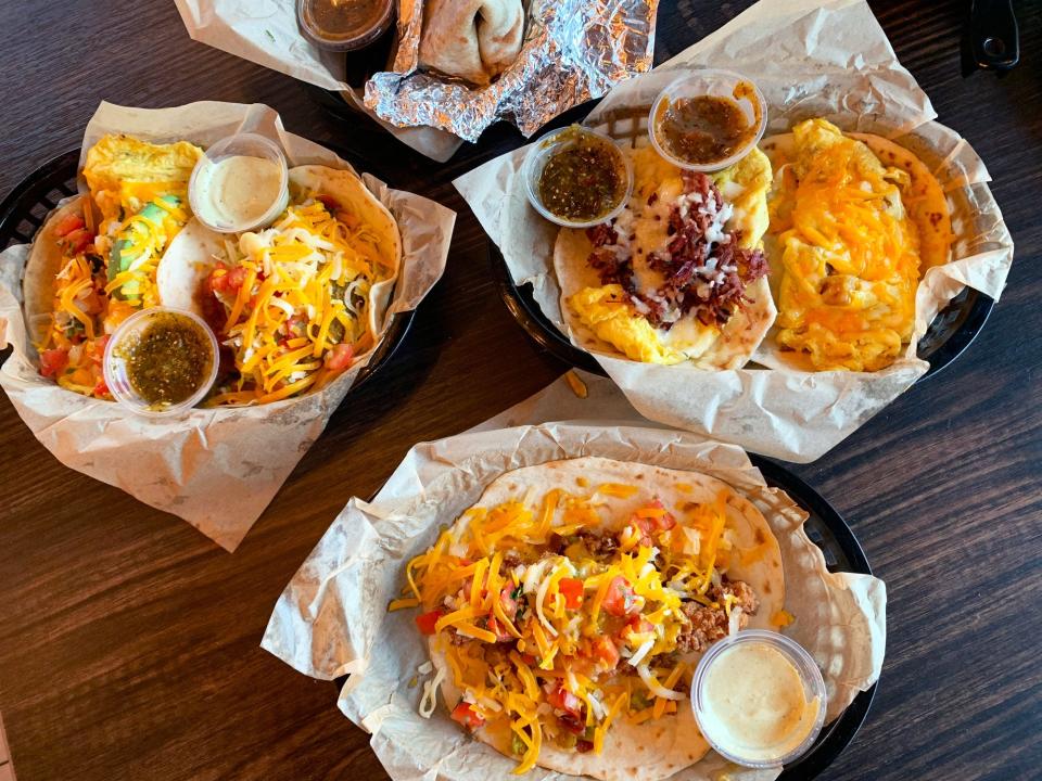 An array of tacos at Torchy's (clockwise from top left): migas taco, fried avocado, the Wrangler, potato, egg and cheese, and the trailer park hillbilly style.
