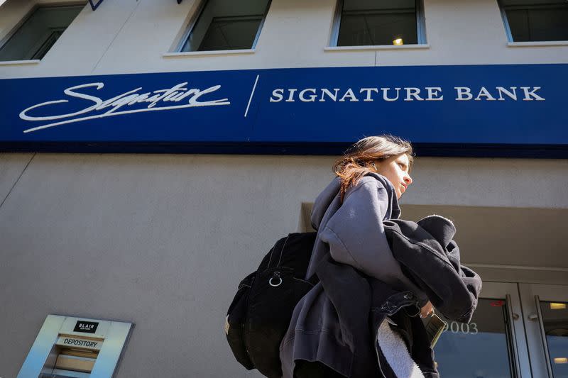 FILE PHOTO: A woman walks past a Signature Bank location in Brooklyn, New York