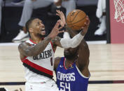 Portland Trail Blazers guard Damian Lillard (0) shoots past Los Angeles Clippers' Patrick Patterson (54) during the second half in an NBA basketball game Saturday, Aug. 8, 2020, in Lake Buena Vista, Fla. (Kim Klement/Pool Photo via AP)