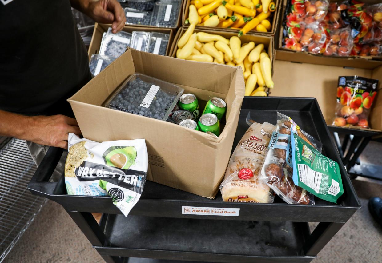 People shop Aug. 22 at AWARE Food Bank’s temporary location at 1530 Mt. Hood Ave. in Woodburn. The AWARE Food Bank is being rebuilt after a fire caused by arson in 2021 damaged its previous building at 152 Arthur St.