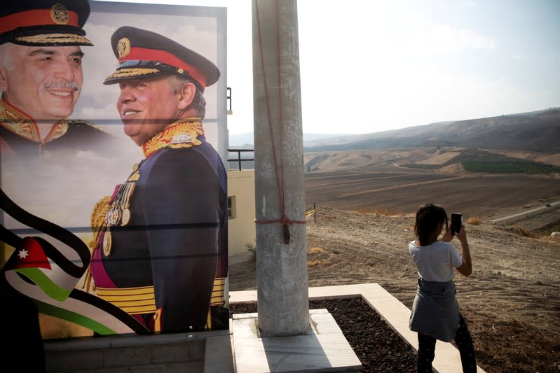 A picture of Jordanian King Abdullah and his father, the late King Hussein, is seen as a girl visits the "Island of Peace" in an area known as Naharayim in Hebrew and Baquora in Arabic, on the Jordanian side of the border with Israel
