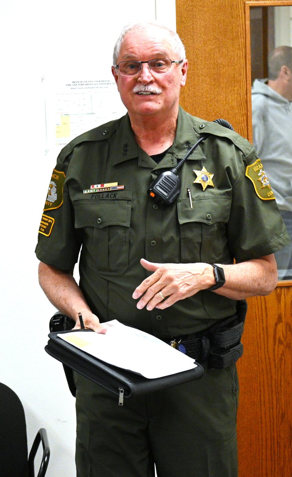 Sheriff John Pollack shows off the new green patrol uniforms now being phased in for new deputies.