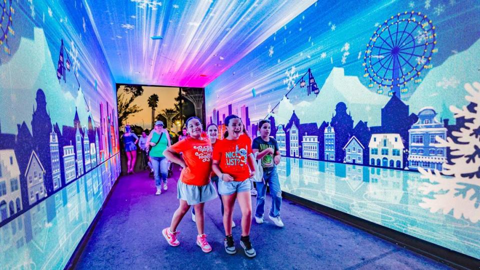 Niños reaccionan mientras caminan a través del Túnel de Inmersión hacia el Tinsel Trail  durante la noche de apertura de Christmas Wonderland en el Tropical Park, en Miami, el viernes 17 de noviembre de 2023.