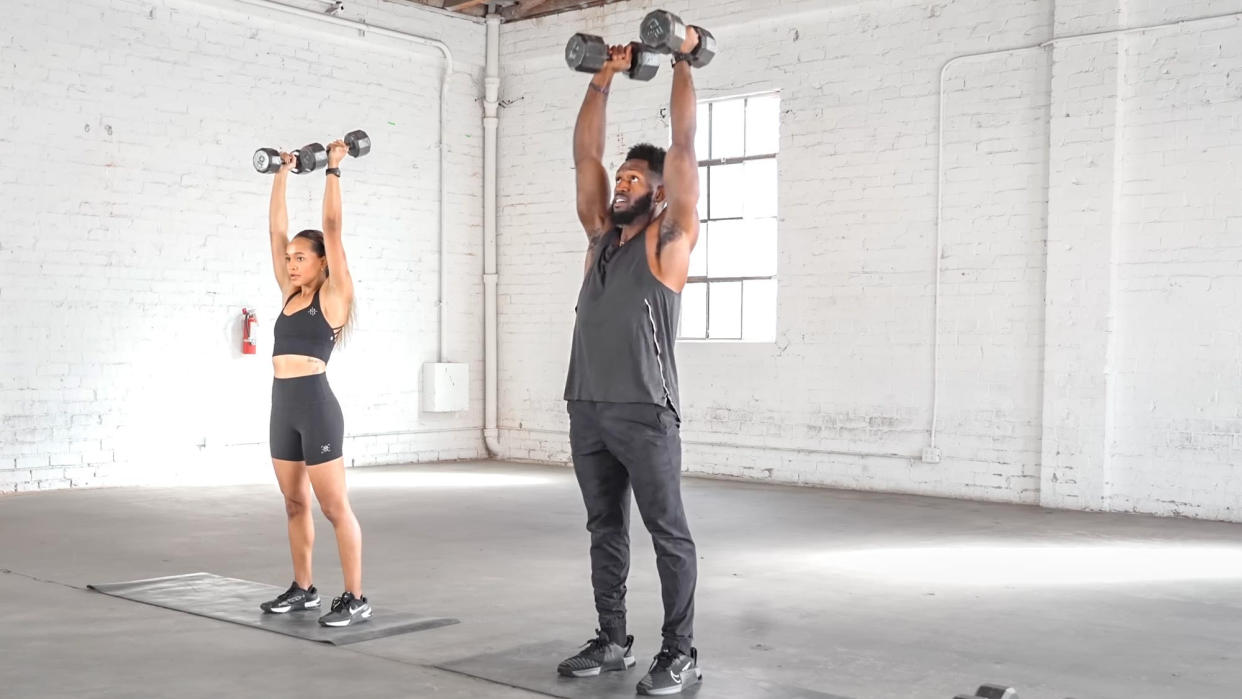  Juice and Toya performing a dumbbell press. 