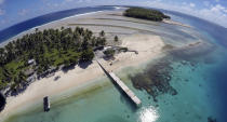 FILE - An aerial photo shows a small section of the atoll that has slipped beneath the water line only showing a small pile of rocks at low tide on Majuro Atoll in the Marshall Islands on Nov. 8, 2015. For decades, the tiny Marshall Islands has been a stalwart American ally. Its location in the middle of the Pacific Ocean has made it a key strategic outpost for the U.S. military. (AP Photo/Rob Griffith, File)