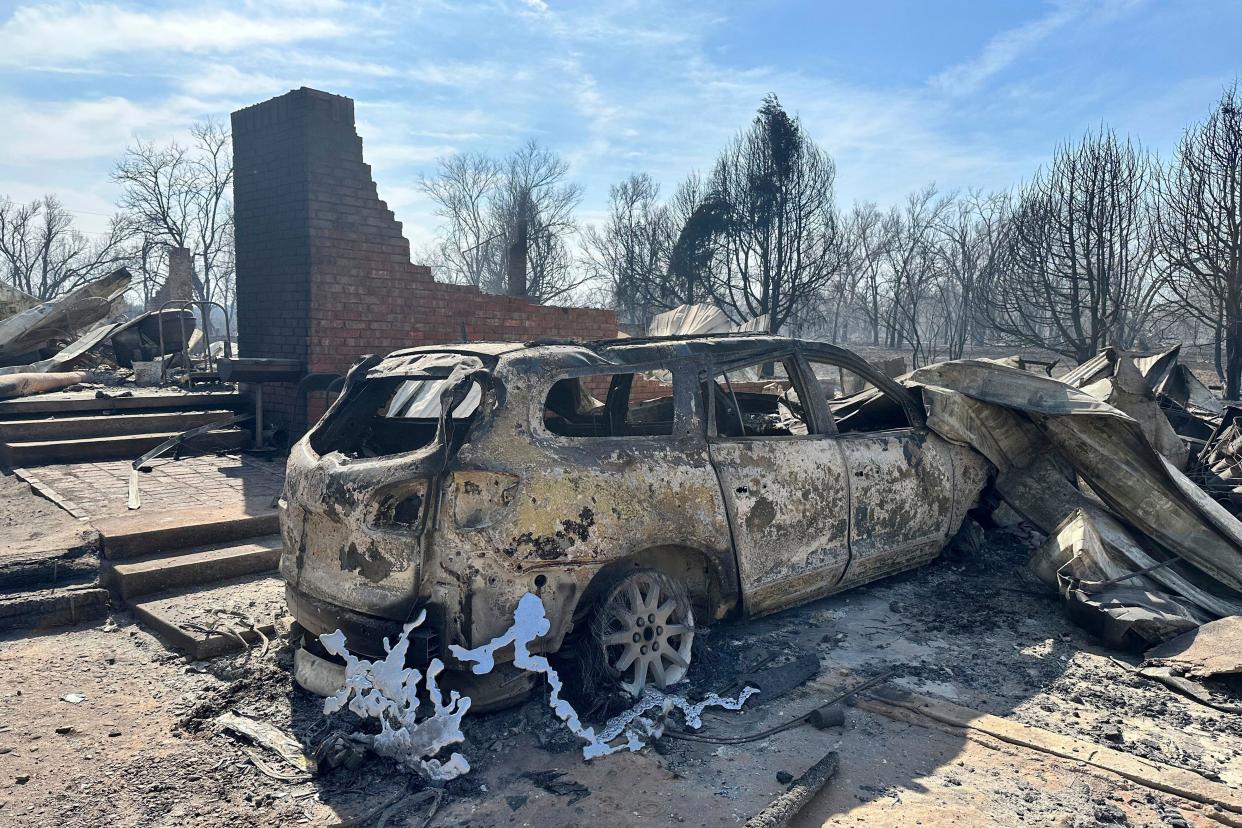 A burned car rests near the charred remains of a home Wednesday outside of Canadian, Texas, after a wildfire passed. A fast-moving wildfire burning through the Texas Panhandle grew into the second-largest blaze in state history Wednesday, forcing evacuations and triggering power outages as firefighters struggled to contain the widening flames.