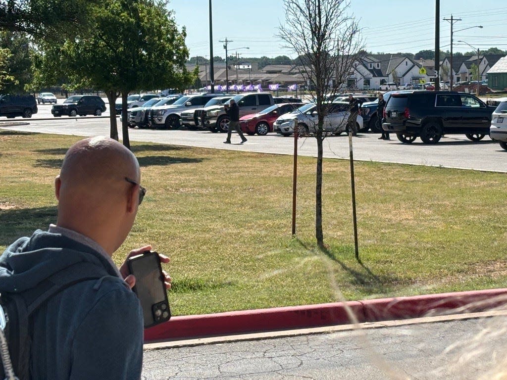 Angel Protection executives Lewis Matthews and Carlos Ortiz demonstrate the effectiveness in the weapon detection systems at Wylie High School Tuesday. The artificial intelligence system picks up Ortiz carrying a large gun in the parking lot approaching the high school from the camera on Wylie ISD Performing Arts Center which alerts Matthews and WISD administrators of the threat.