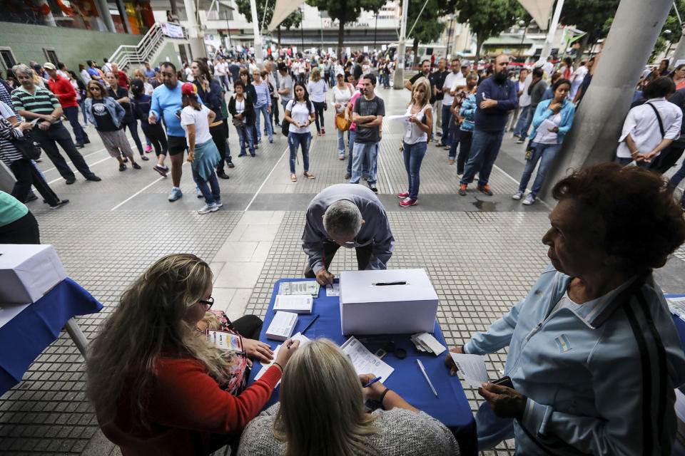 <p>Venezuelan cast their vote during a poll called ‘popular consultation’ at Colon Square in in Caracas, Venezuela on 16 July 2017. Venezuelans are able to vote organised by the opposition to express their support or rejection to the plan by President Nicolas Maduro to rewrite the constitution through an election of a citizens’ body on July 30, 2017. (Miguel Gutierrez/EPA/REX/Shutterstock) </p>