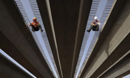 Labourers work on building a highway to connect Kashgar and Aksu by the end of October 2013 in Aksu, Xinjiang Uighur Autonomous Region, September 6, 2012. REUTERS/Stringer