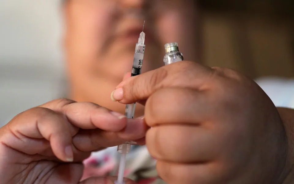 A woman with Type 2 diabetes prepares to inject herself with insulin - John Locher/AP Photo