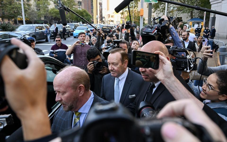 Actor Kevin Spacey is surrounded by members of the media and fans as he leaves the US District Courthouse - Getty