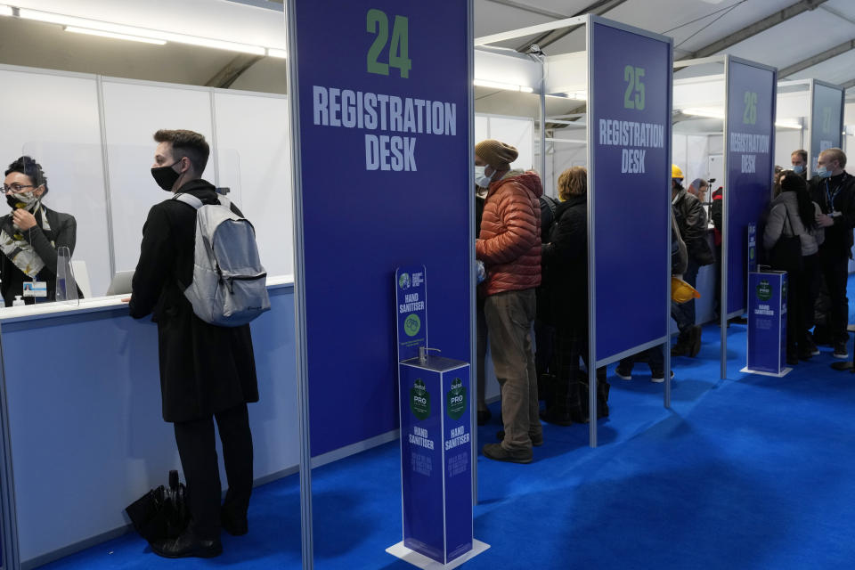 FILE - In this Oct. 29, 2021, file photo, attendees wait for registration to enter the venue where the U.N. climate conference will be held in Glasgow, Scotland. Despite the concerns about the coronavirus from some of the delegates from around the world, the British government decided to hold an in-person conference, arguing that world leaders must act now to prevent catastrophic global warming — and that they will be more effective if they can talk face-to-face. (AP Photo/Matt Dunham, File)