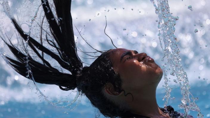 A girl whips her wet hair on 25 July 2023