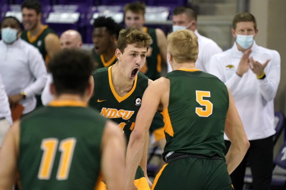 North Dakota State forward Rocky Kreuser (34) center, celebrates his 3-point basket with Jarius Cook (11) and Sam Griesel (5) as head coach David Richman, right rear, and the rest of the bench look on in the second half of an NCAA college basketball game against TCU in Fort Worth, Texas, Tuesday, Dec. 22, 2020. (AP Photo/Tony Gutierrez)