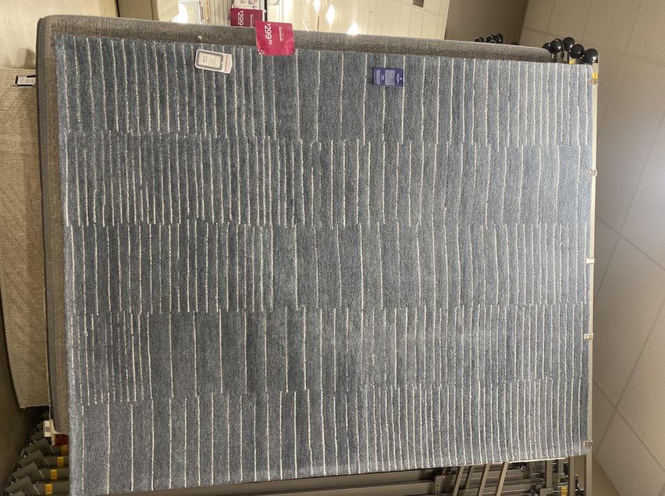 a large gray rug with lines in a homegoods store