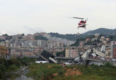 A rescue helicopter flies over the collapsed Morandi Bridge in the Italian port city of Genoa, Italy August 14, 2018. REUTERS/Stefano Rellandini