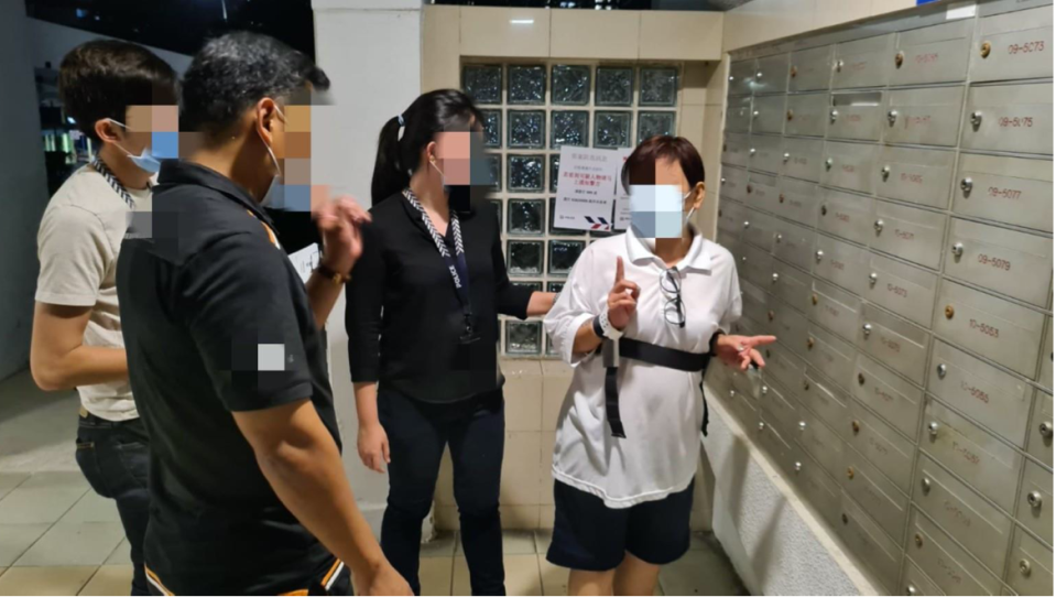 A female suspect escorted to crime scene to identify letterboxes which she stole Budget 2020 Grocery Vouchers from. (PHOTO: Singapore Police Force)