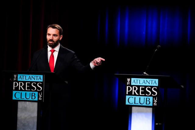 Georgia U.S. Senate candidate Latham Saddler points at an empty podium belonging to candidate Herschel Walker as he participates in a Republican primary debate on Tuesday, on May 3, 2022, in Atlanta. - Credit: Brynn Anderson/AP Images