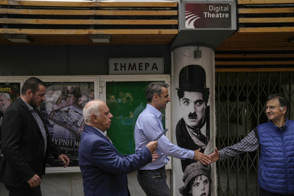 Greece's Prime Minister and New Democracy leader Kyriakos Mitsotakis shakes hands with a man outside an outdoor cinema, during his election campaign in northern Athens, Greece, Monday, May 1, 2023. (AP Photo/Thanassis Stavrakis)