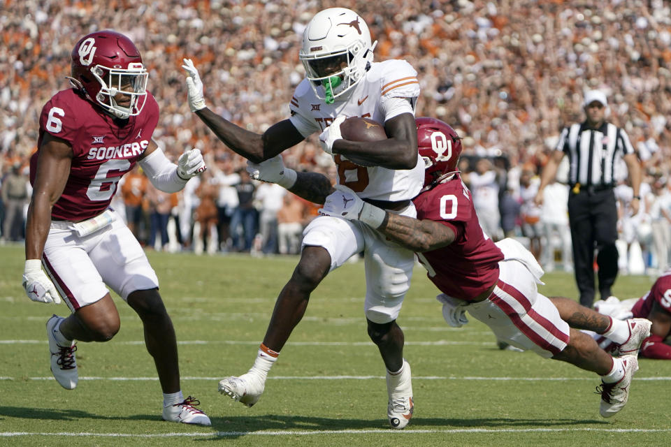 Texas wide receiver Xavier Worthy (8) runs against Oklahoma defensive backs Woodi Washington (0) and Trey Morrison (6) during the first half of an NCAA college football game at the Cotton Bowl in Dallas, Saturday, Oct. 8, 2022. (AP Photo/LM Otero)