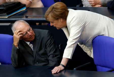 FILE PHOTO: German Finance Minister Wolfgang Schaeuble (L) listens to Chancellor Angela Merkel as they attend a debate on the consequences of the Brexit vote at the lower house of parliament Bundestag in Berlin, Germany, June 28, 2016. REUTERS/Fabrizio Bensch/File Photo