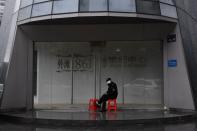 Security guard wearing a face mask keeps watch at an entrance to a residential building in Wuhan