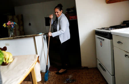 Sandra Gutierrez, who fled from gang violence in Honduras with her family and was granted asylum by the United States in 2016, sweeps the floor at her home in Oakland, California, U.S., May 30, 2017. Picture taken May 30, 2017. REUTERS/Stephen Lam