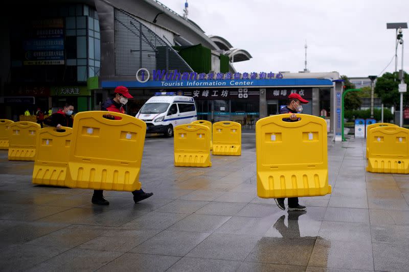 Staff members move barriers in front of a railway station of Wuhan on the first day of inbound train services resumed following the novel coronavirus disease (COVID-19) outbreak, in Wuhan