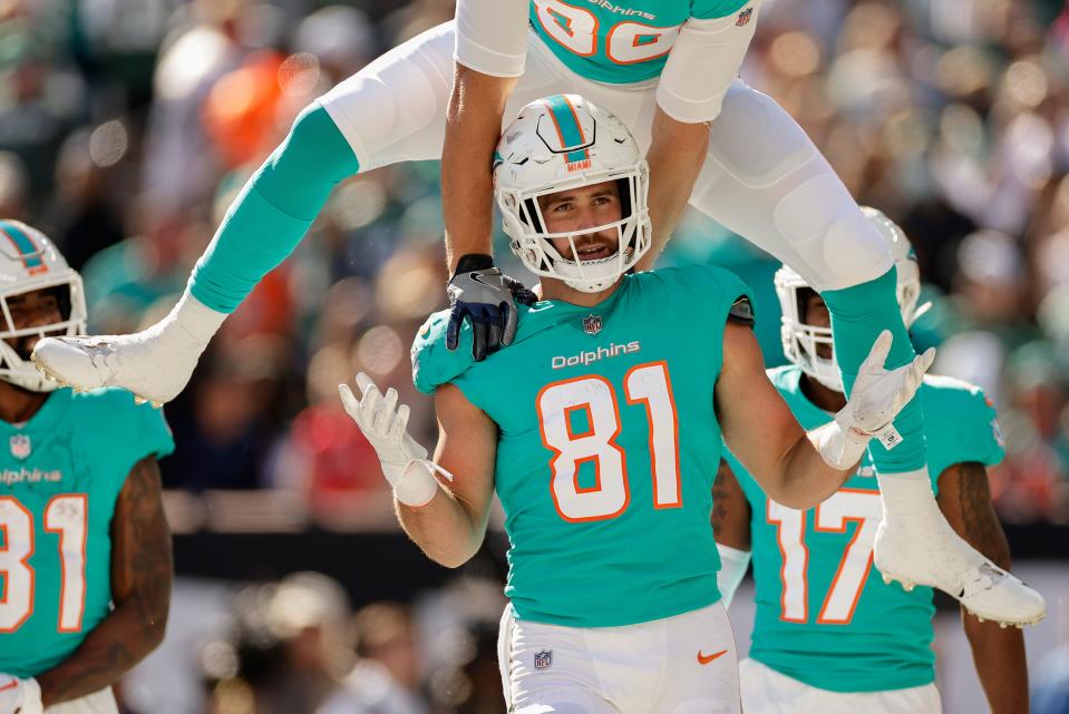 Miami Dolphins tight end Durham Smythe (81) reacts as tight end Mike Gesicki (88) leaps over his shoulders after Smythe scored a touchdown against the New York Jets during the second quarter of an NFL football game, Sunday, Oct. 9, 2022, in East Rutherford, N.J. (AP Photo/Adam Hunger)