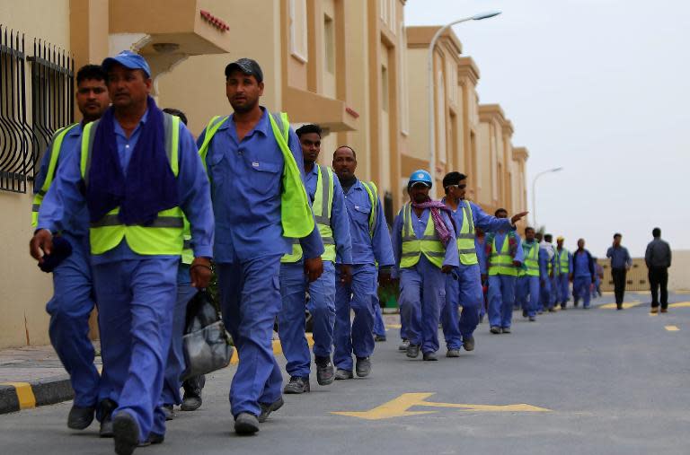 Foreign laborers at the construction site of the al-Wakrah football stadium walk back to their accommodation at the Ezdan 40 compound on May 4, 2015 after finishing work