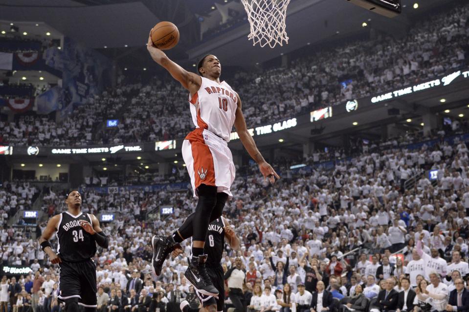 Toronto Raptors' DeMar DeRozan (10) goes up for a dunk as Brooklyn Nets' Paul Pierce (34) and Deron Williams (8) look on during the first half of Game 5 of the opening-round NBA basketball playoff series in Toronto, Wednesday, April 30, 2014. (AP Photo/The Canadian Press, Frank Gunn)