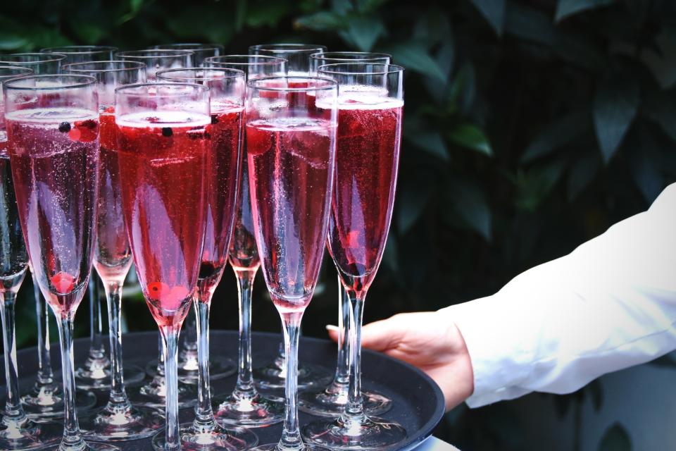 A person holding a tray of drinks