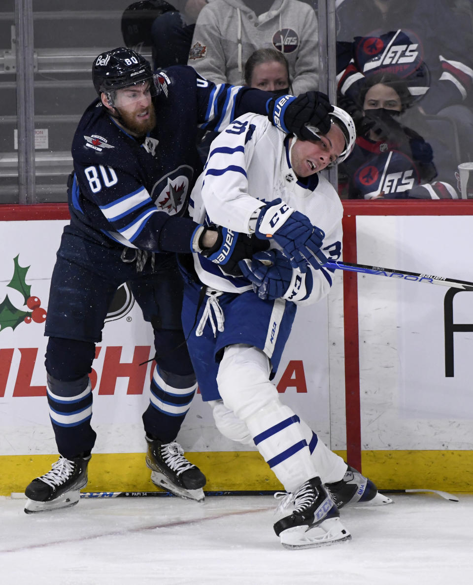 Winnipeg Jets' Pierre-Luc Dubois (80) and Toronto Maple Leafs' Auston Matthews (34) tangle during the third period of NHL hockey game action in Winnipeg, Manitoba, Sunday, Dec. 5, 2021. (Fred Greenslade/The Canadian Press via AP)
