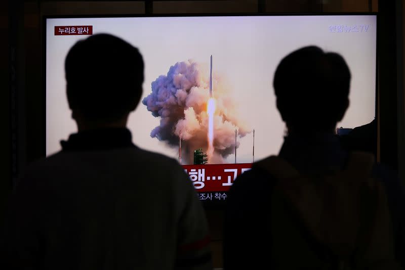 People watch a TV broadcasting a news report on the KSLV-II NURI rocket launching from its launch pad of the Naro Space Center, at a railway station in Seoul