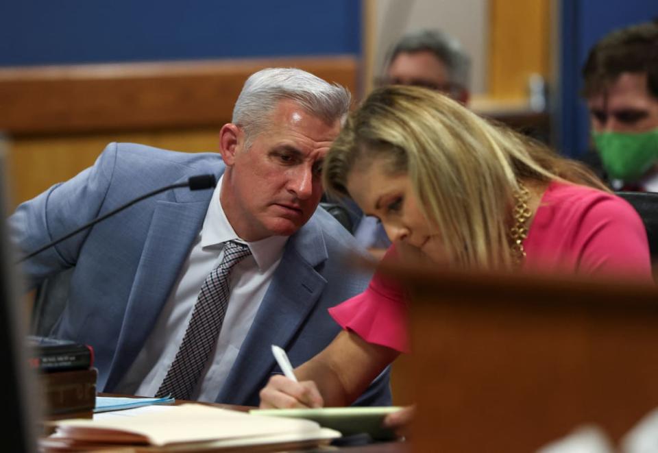 John Merchant, attorney for Michael Roman, looks at his wife Ashleigh Merchant.