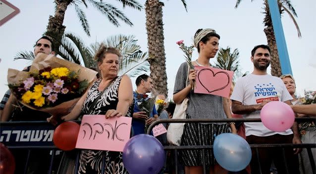 Protesters hold signs in support of the wedding of groom Mahmoud Mansour, 26, and bride Maral Malka, 23, outside a wedding hall in Rishon Lezion. Photo: Reuters.