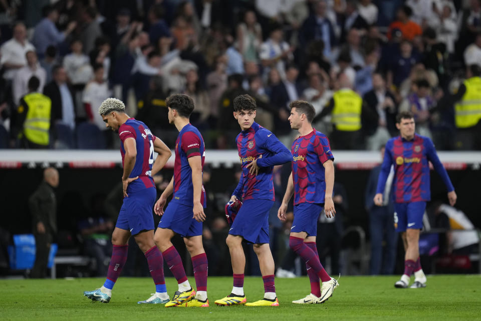 Barcelona players react as they leave the field at the end of the Spanish La Liga soccer match between Real Madrid and Barcelona at the Santiago Bernabeu stadium in Madrid, Spain, Sunday, April 21, 2024. (AP Photo/Manu Fernandez)