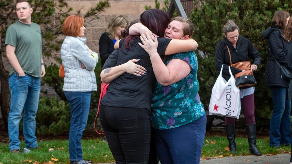 People are pictured hugging outside the Boise Towne Square shopping mall in Boise, Idaho, after authorities said a shooting left 2 people dead and 4 others, including a police officer, injured Monday.