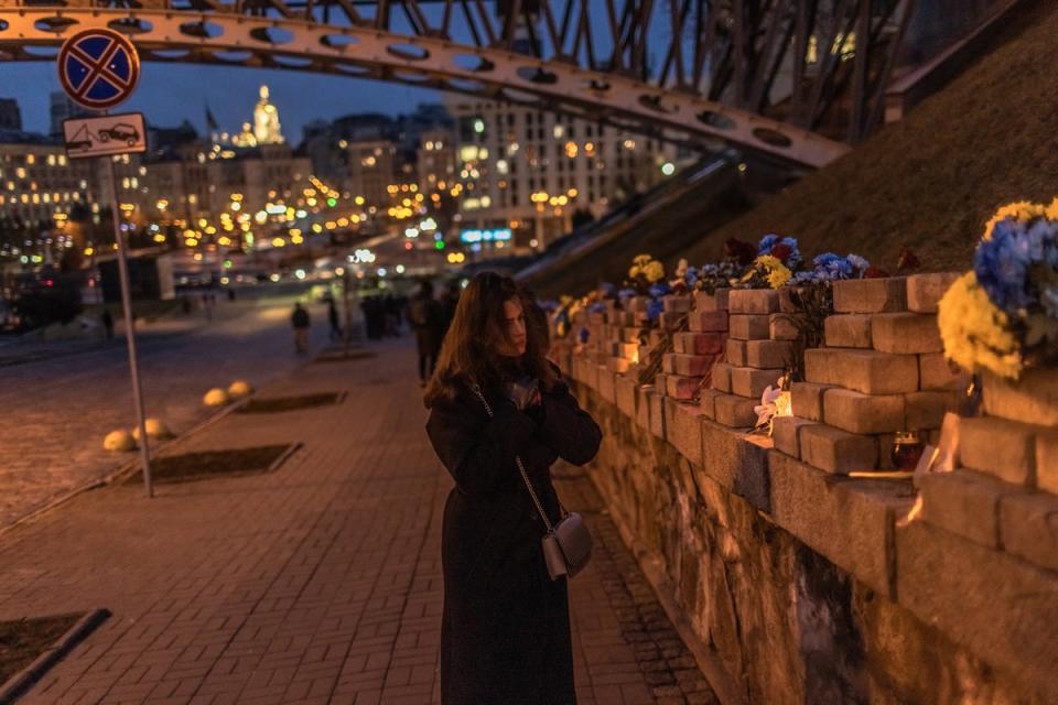 A woman visits the memorial to the Heavenly hundred heroes, who were killed in 2014 during the mass Euromaidan protests, on the Day of Remembrance of Heroes of Heavenly Hundred, on February 20, 2023 in Kyiv, Ukraine (Getty Images)
