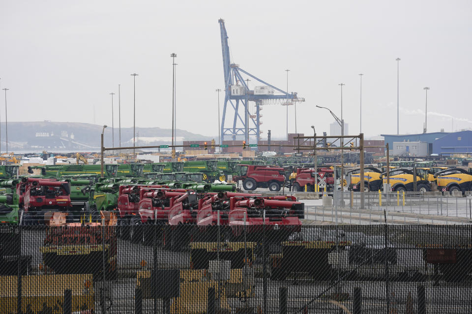 A crane stands idle above farm equipment on Thursday, March 28, 2024, in Dundalk, Md. The deadly collapse of the historic Francis Scott Key Bridge has shaken Baltimore to its core and challenged its cultural identity as a port city that dates back to before the U.S. declared its independence. (AP Photo/Matt Rourke)