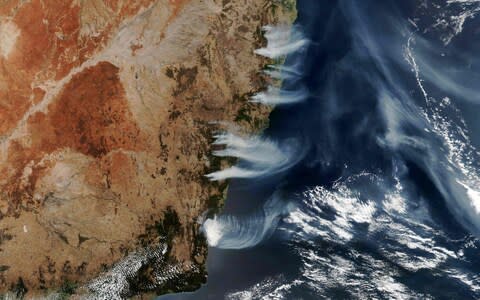 This NASA Earth Observatory handout from 4 December shows fires burning near the coast of New South Wales, near Canberra and areas north to the border with Queensland, Australia - Credit: Lauren Dauhpin/AFP