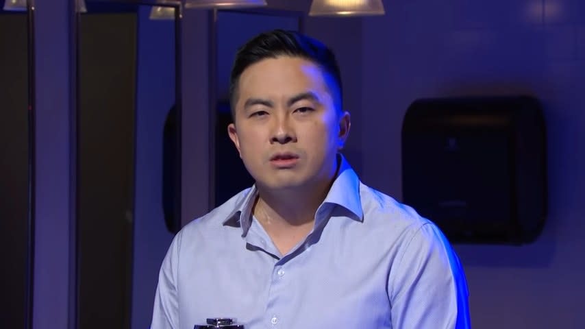 Bowen Yang staring at the camera in a men's room in "Saturday Night Live"