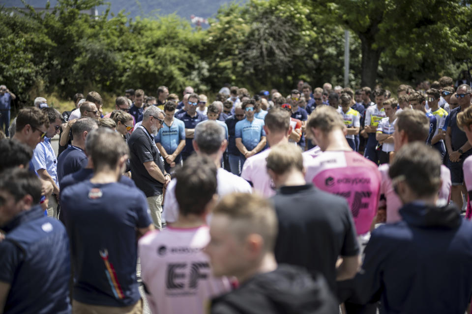 Event director Olivier Senn, center left, holds a minute of silence in honour of Gino Maeder from Switzerland of Bahrain-Victorious, who died following his crash the day before, at the 86th Tour de Suisse UCI World Tour cycling race, in Chur, Switzerland, Friday, June 16, 2023. (Gian Ehrenzelle/Keystone via AP)