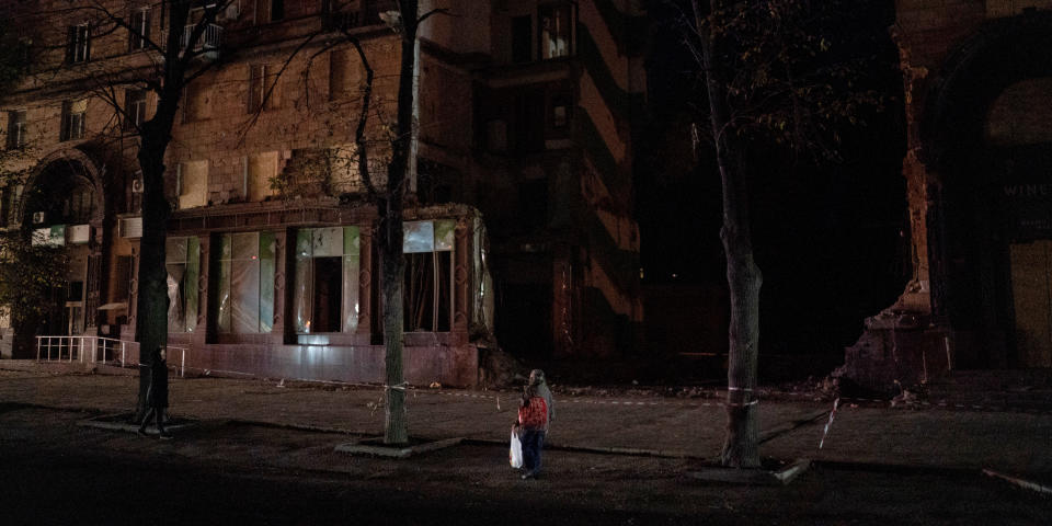 Passanten betrachten ein beschädigtes Gebäude in der ukrainischen Stadt Saporischschja (Bild: Leo Correa/AP/dpa)
