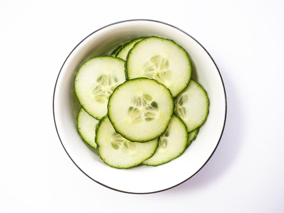 directly above view of cucumber slices in bowl on white background