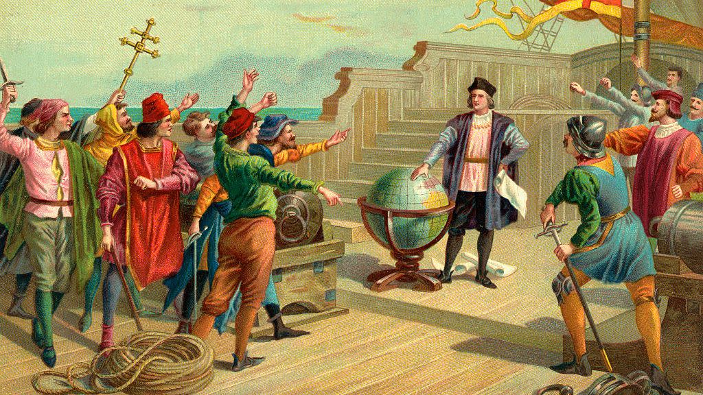 vintage color illustration of christopher columbus standing on a ship deck with one hand on a large globe and the other on his hip holding a paper scroll, he wears a hat, dark jacket, long sleeve shirts, dark pants and leggings, several people surround him on the deck many with their hands out toward him