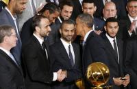 U.S. President Barack Obama shakes hands with player Manu Ginobili as he honors the NBA defending champion San Antonio Spurs basketball team at the White House in Washington January 12, 2015. Between them is Spurs guard Tony Parker. REUTERS/Kevin Lamarque (UNITED STATES - Tags: POLITICS SPORT BASKETBALL)